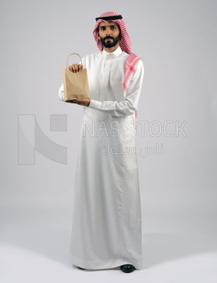 Gulf man carrying a shopping bag