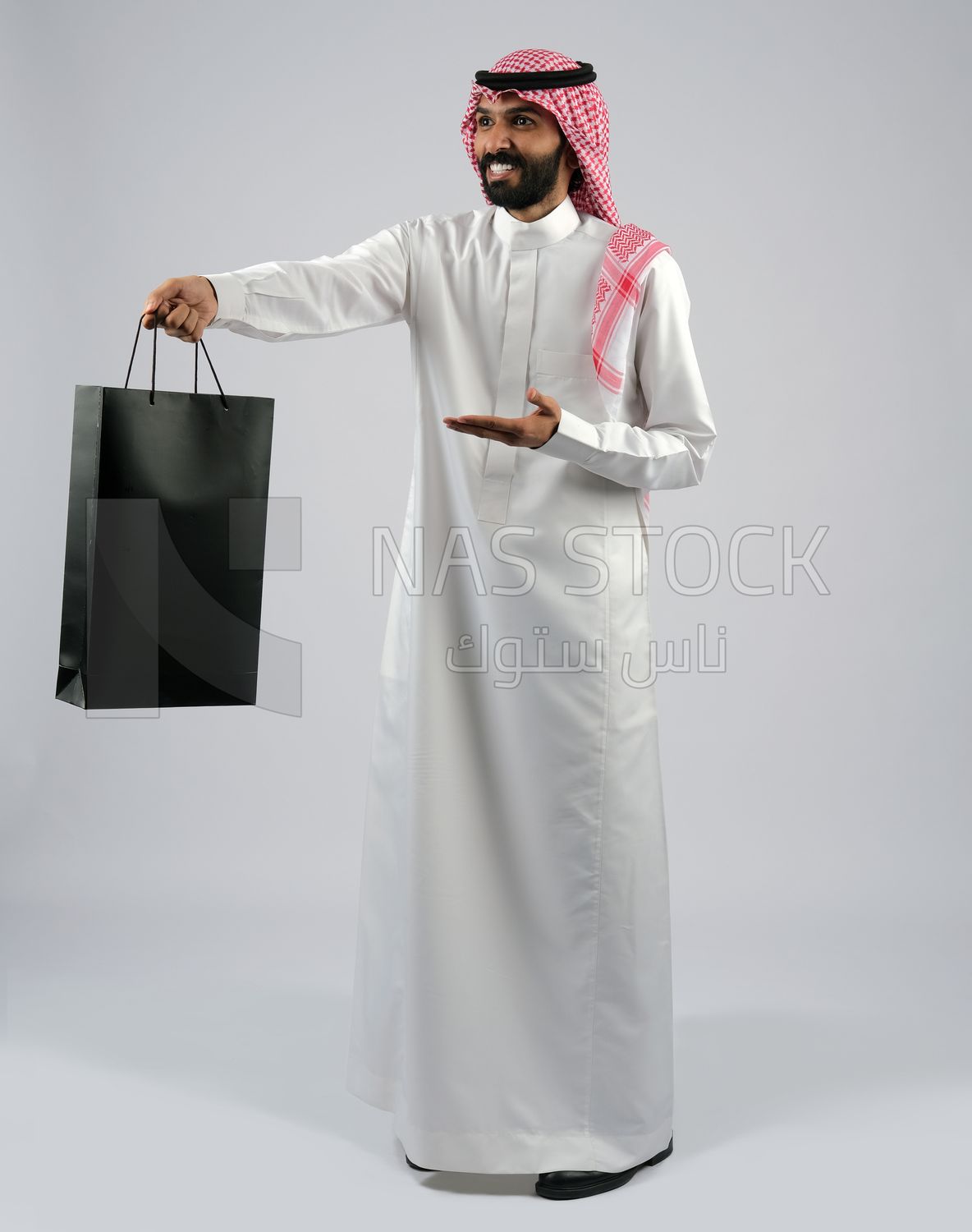 Gulf man carrying a shopping bag