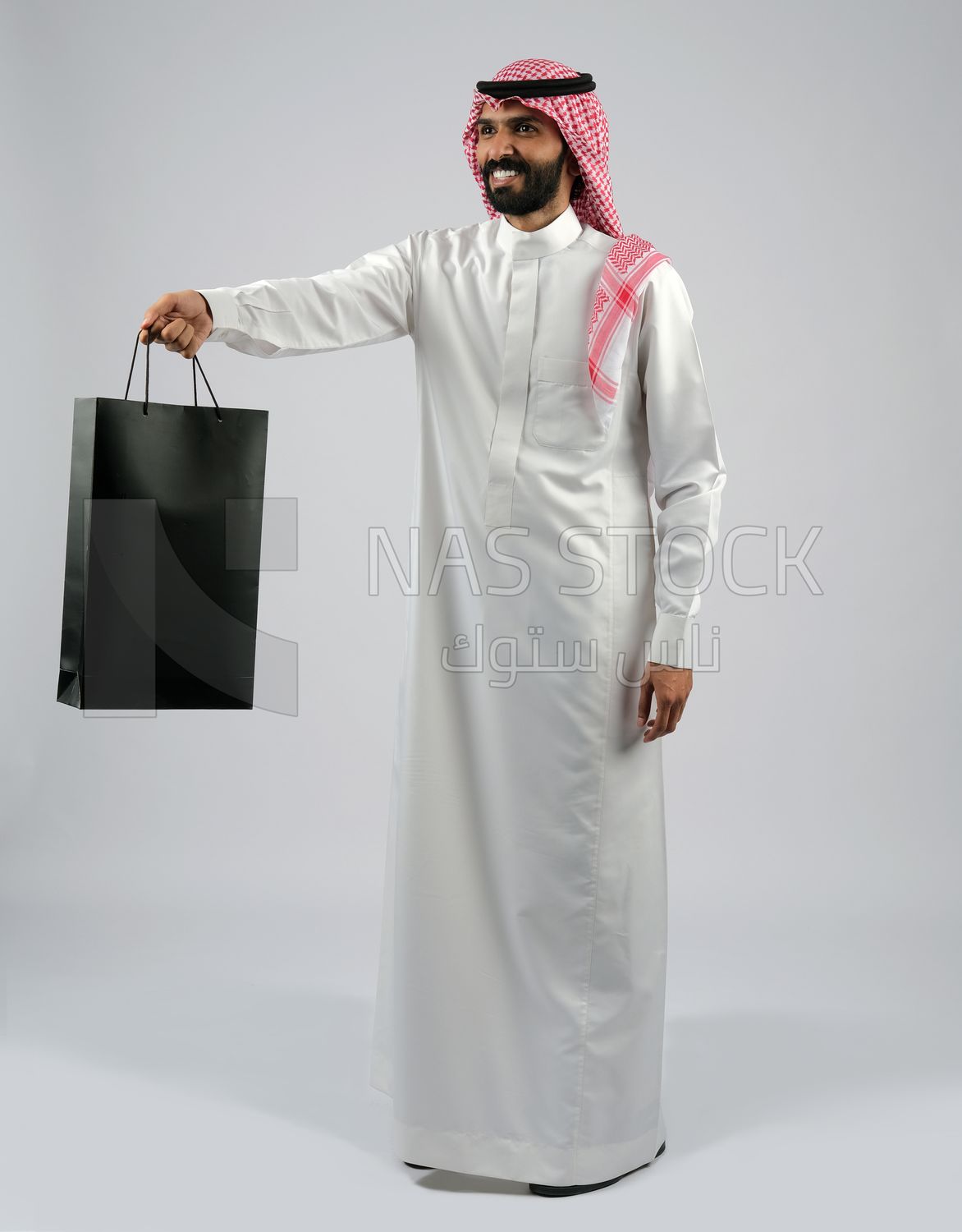 Gulf man carrying a shopping bag