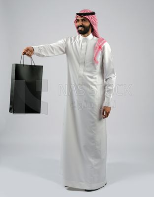 Gulf man carrying a shopping bag