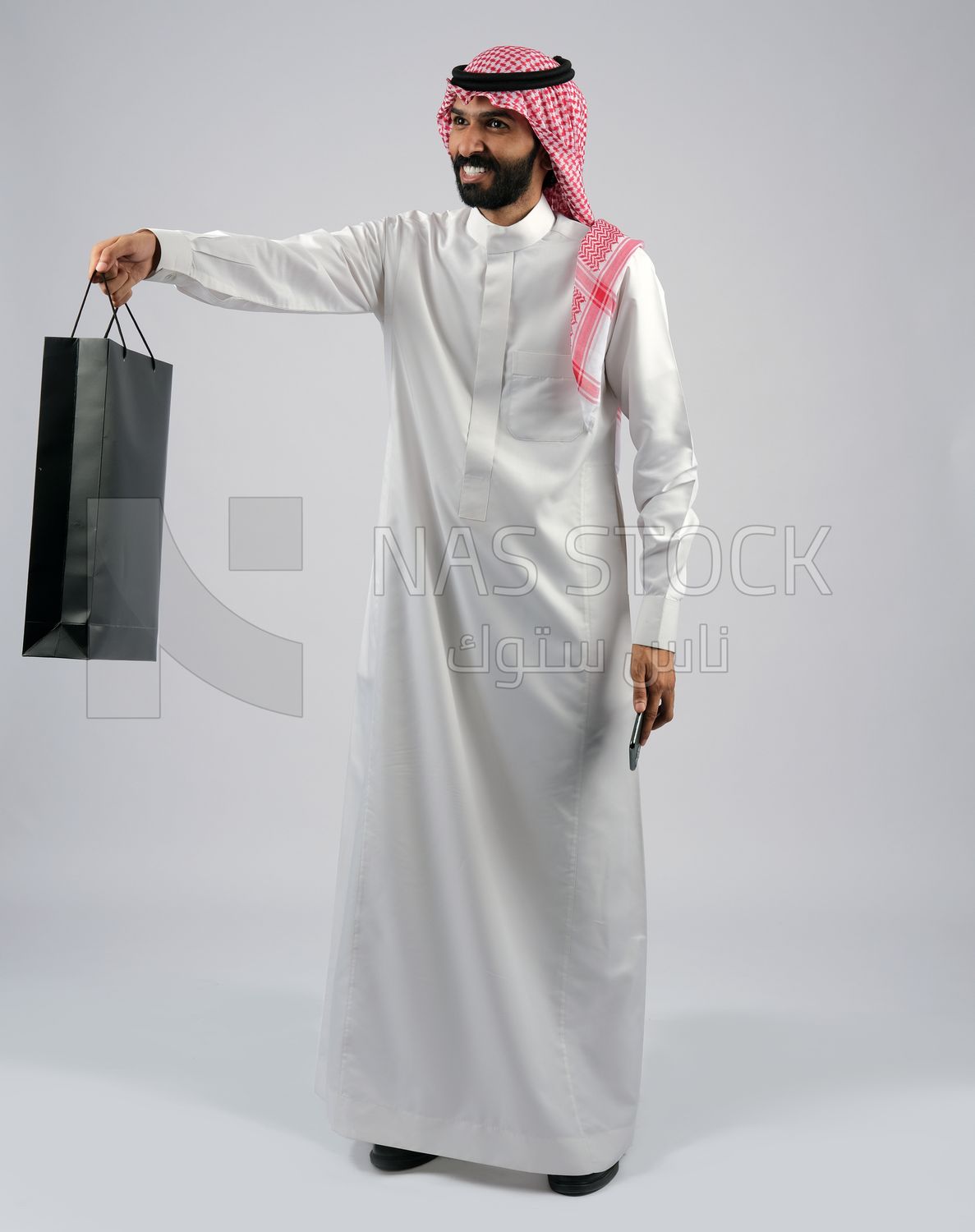 Gulf man carrying a shopping bag