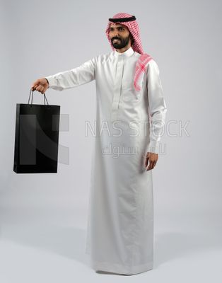 Gulf man carrying a shopping bag