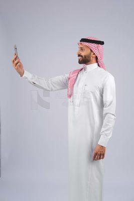 Gulf man holding a mobile phone