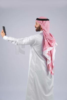 Gulf man holding a mobile phone
