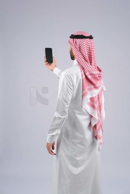 Gulf man holding a mobile phone