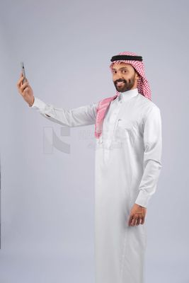 Gulf man holding a mobile phone