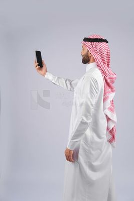 Gulf man holding a mobile phone