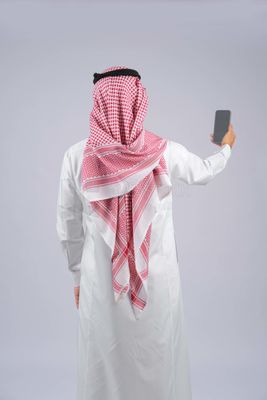 Gulf man holding a mobile phone