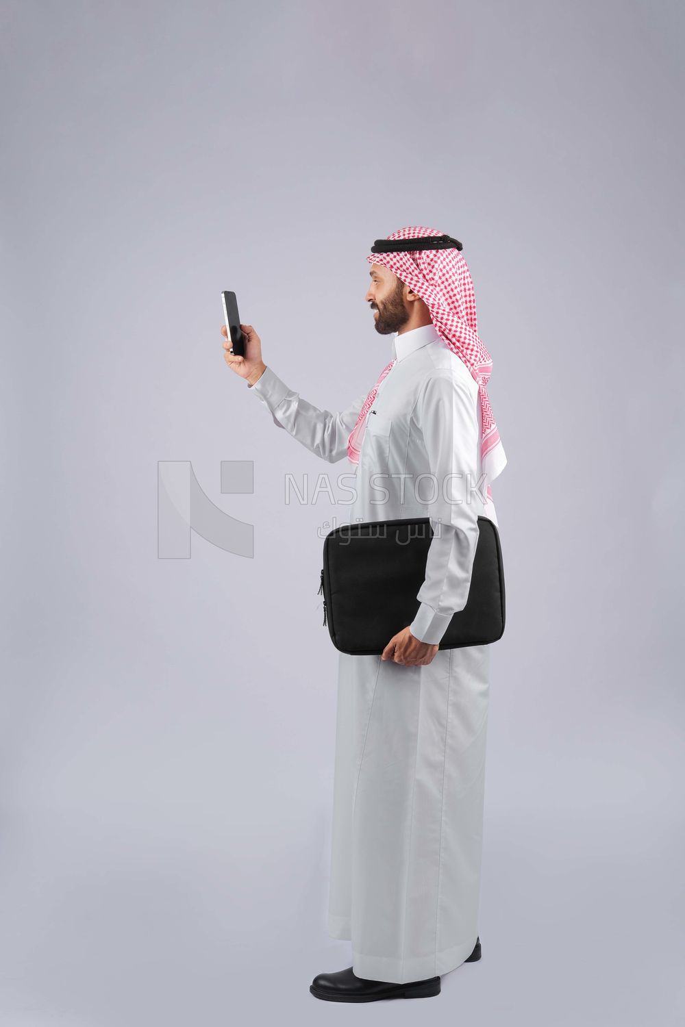 Gulf man holding a business bag and a phone
