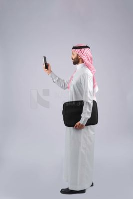 Gulf man holding a business bag and a phone