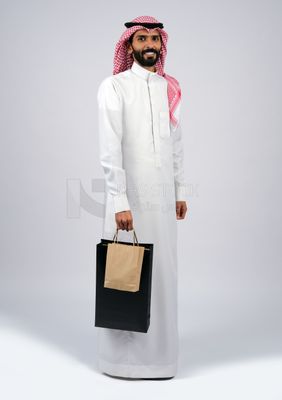 Gulf man carrying shopping bags