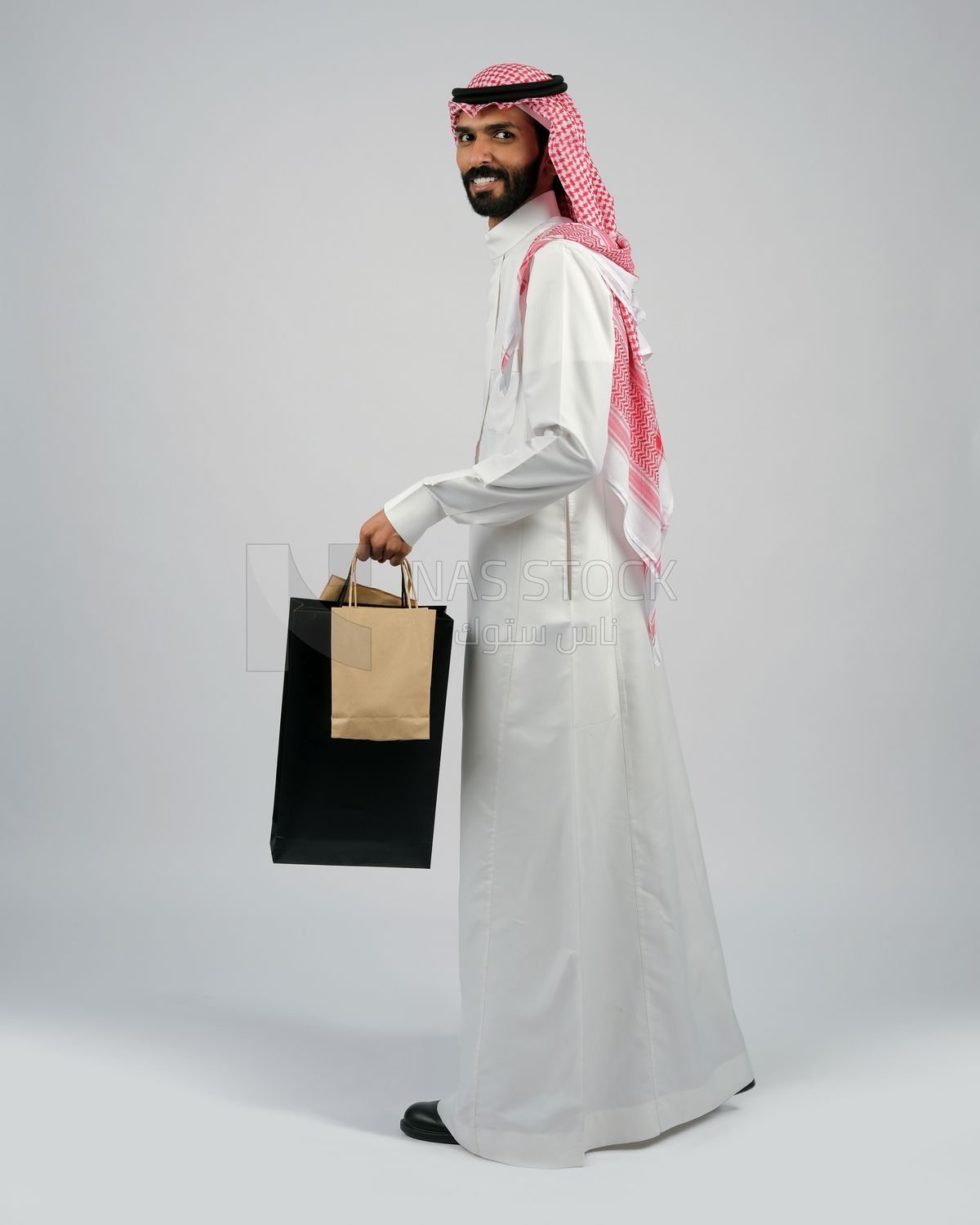 Gulf man carrying shopping bags