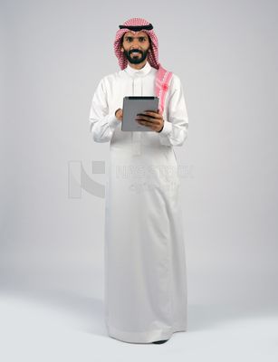 رجل خليجي يحمل تابلت