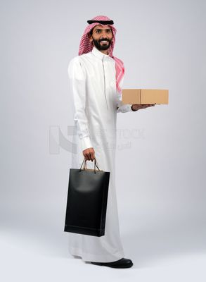 Gulf man holding a box and bags of purchases