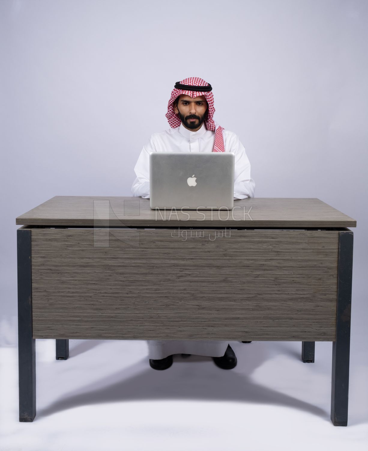 Gulf man sitting at desk using laptop
