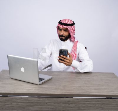 Gulf man sitting at desk using laptop
