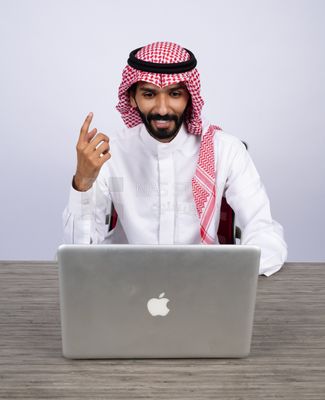 Gulf man sitting at desk using laptop