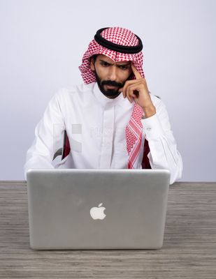 Gulf man sitting at desk using laptop