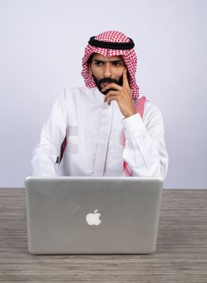 Gulf man sitting at desk using laptop
