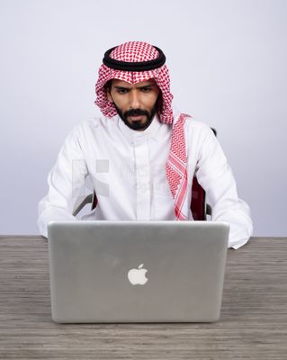 Gulf man sitting at desk using laptop