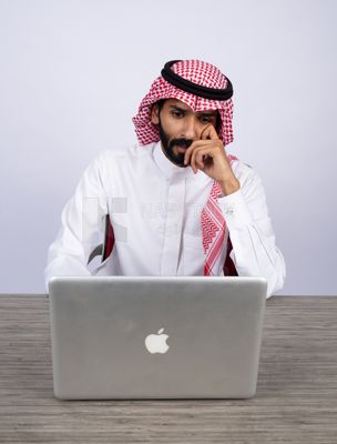Gulf man sitting at desk using laptop