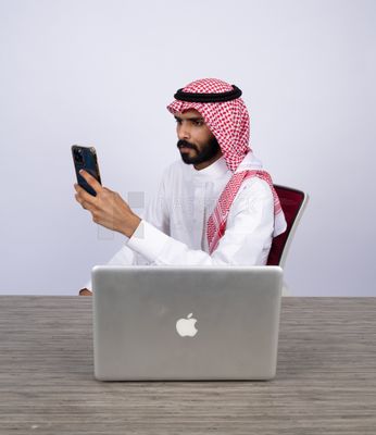 Gulf man sitting at desk using phone