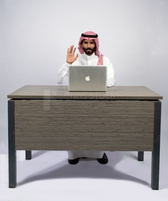 Gulf man sitting at desk using laptop