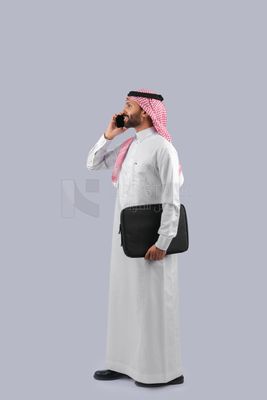 Gulf man carrying handbag and making a phone call
