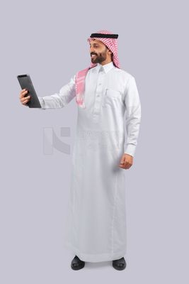 رجل خليجي يحمل جهاز لوحي