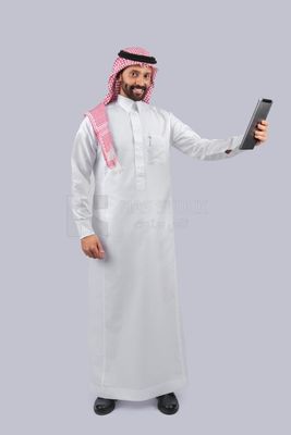 رجل خليجي يحمل جهاز لوحي