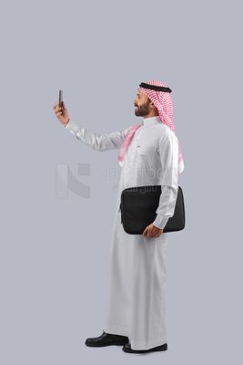 Gulf man holding a handbag and making a video call