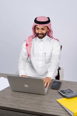 Gulf man sitting at desk using laptop
