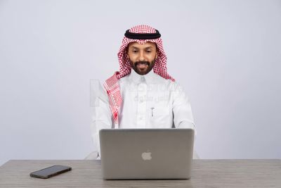 Gulf man sitting at desk using laptop