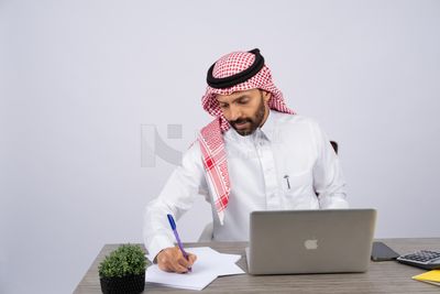 Gulf man sitting at desk using laptop