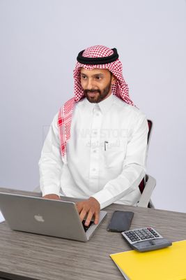 Gulf man sitting at desk using laptop
