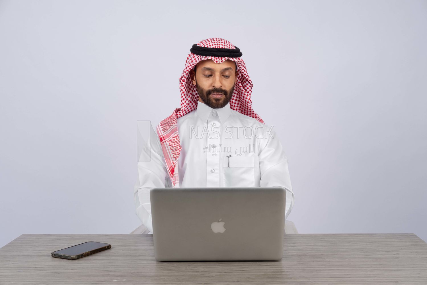 Gulf man sitting at desk using laptop