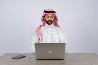 Gulf man sitting at desk using laptop