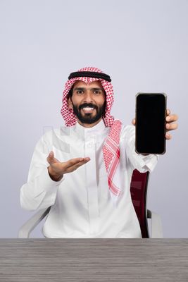 Gulf man holding a mobile phone