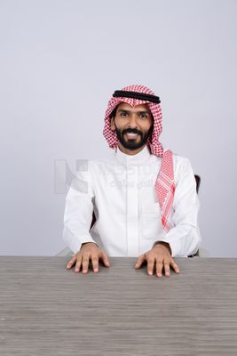رجل خليجي يعمل على مكتب