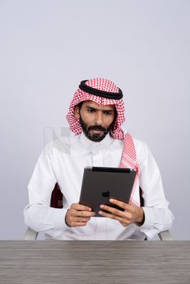 رجل خليجي يستخدم جهاز لوحي