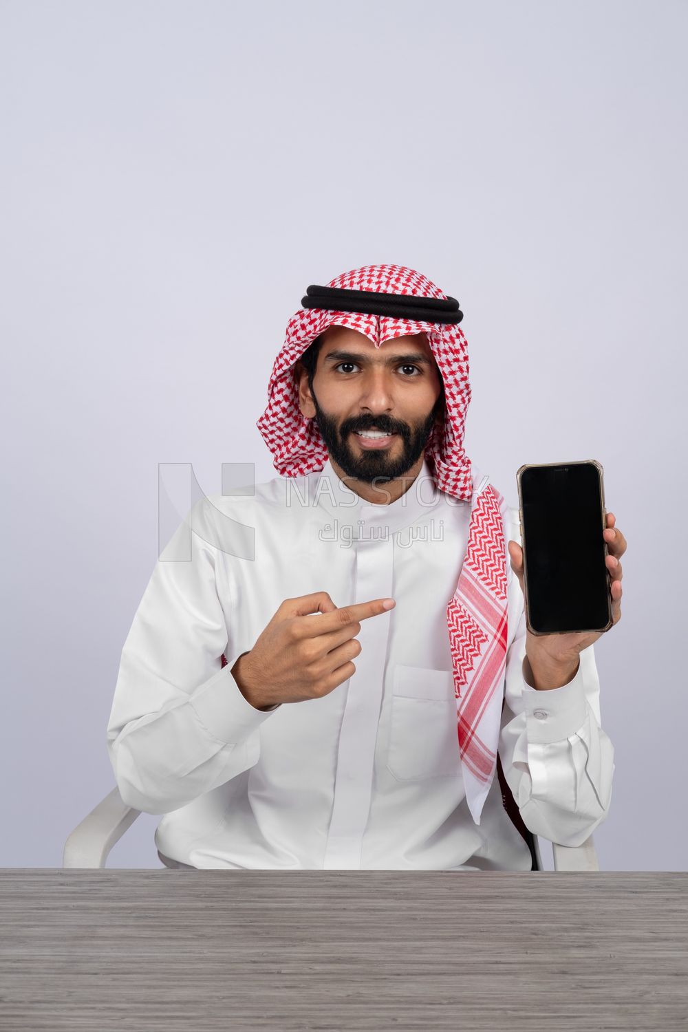 Gulf man holding a mobile phone