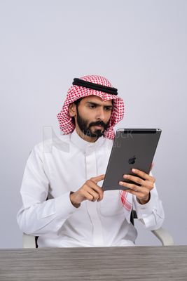 رجل خليجي يستخدم جهاز لوحي