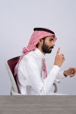 رجل خليجي يعمل على مكتبه