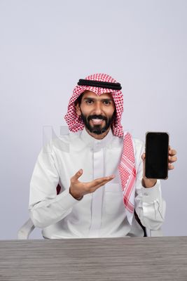 Gulf man holding a mobile phone
