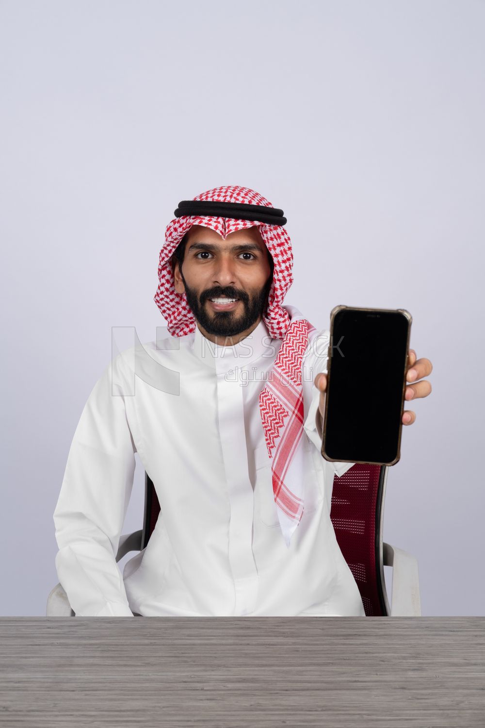 Gulf man holding a mobile phone