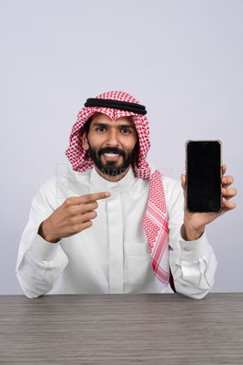 Gulf man holding a mobile phone