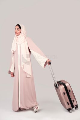 Veiled Gulf girl with suitcase