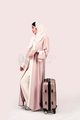 Veiled Gulf girl with suitcase