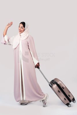 Veiled Gulf girl with suitcase