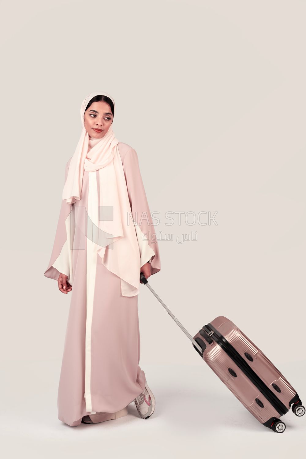 Veiled Gulf girl with suitcase